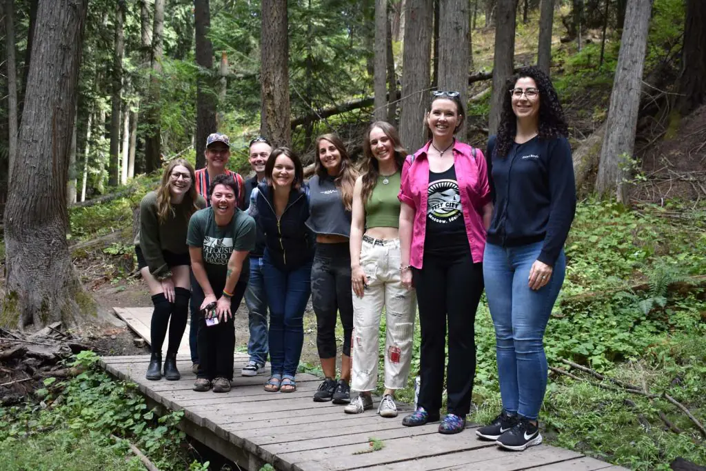 Group of people standing on a small bridge in a forest