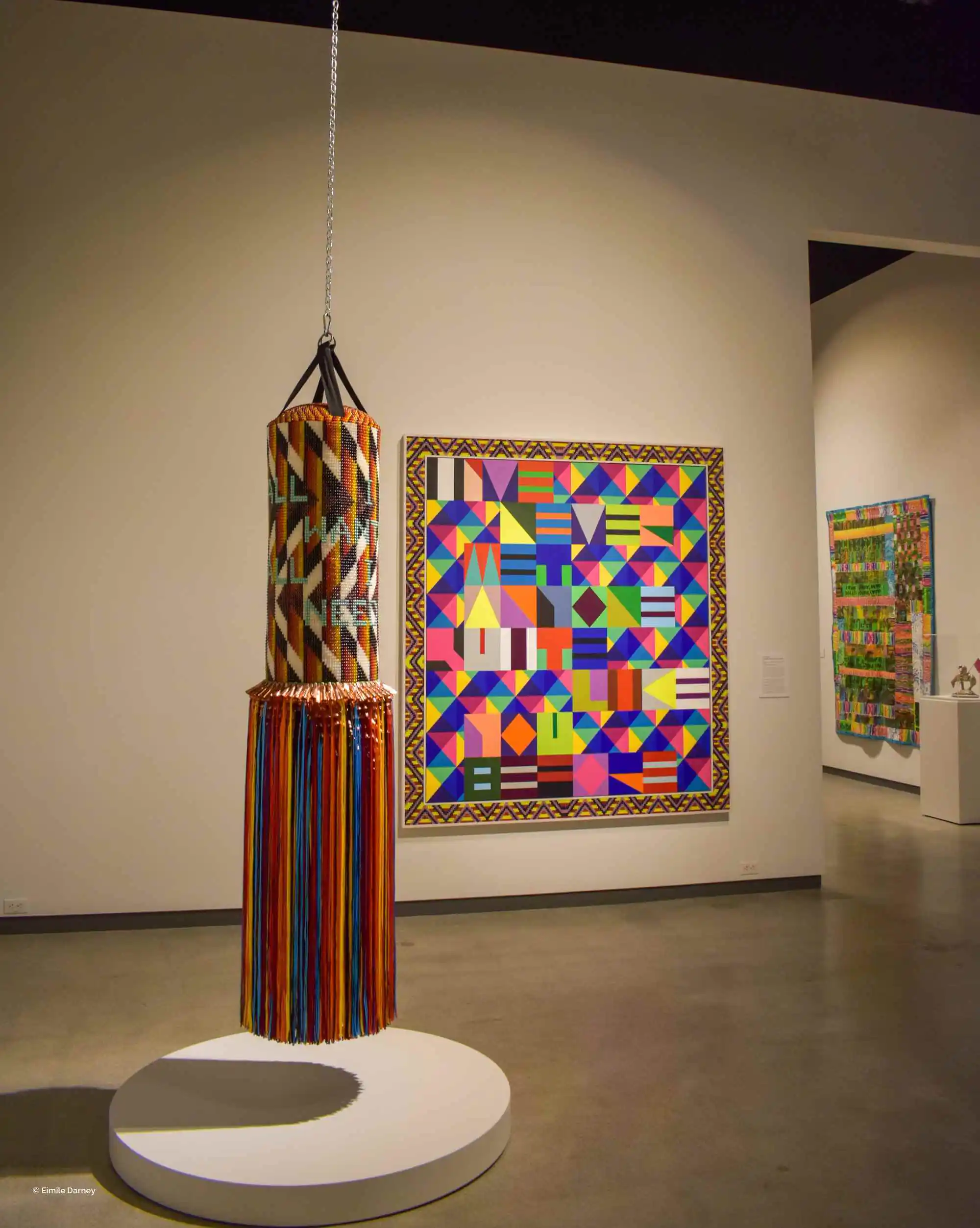 Museums Colorful textile punching bag and geometric artwork displayed in a museum