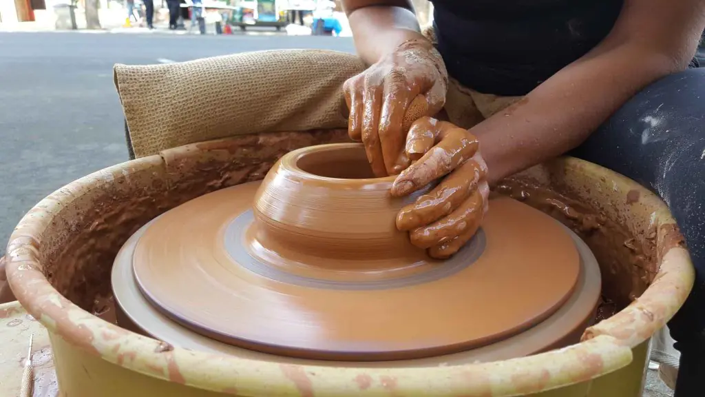 Close-up of hands sculpting a clay pot on a pottery wheel